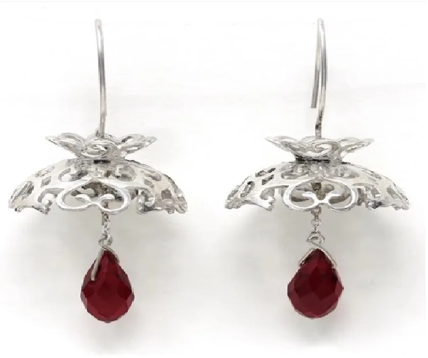 Silver filigree drop earrings with teardrop garnet gemstones on a white background