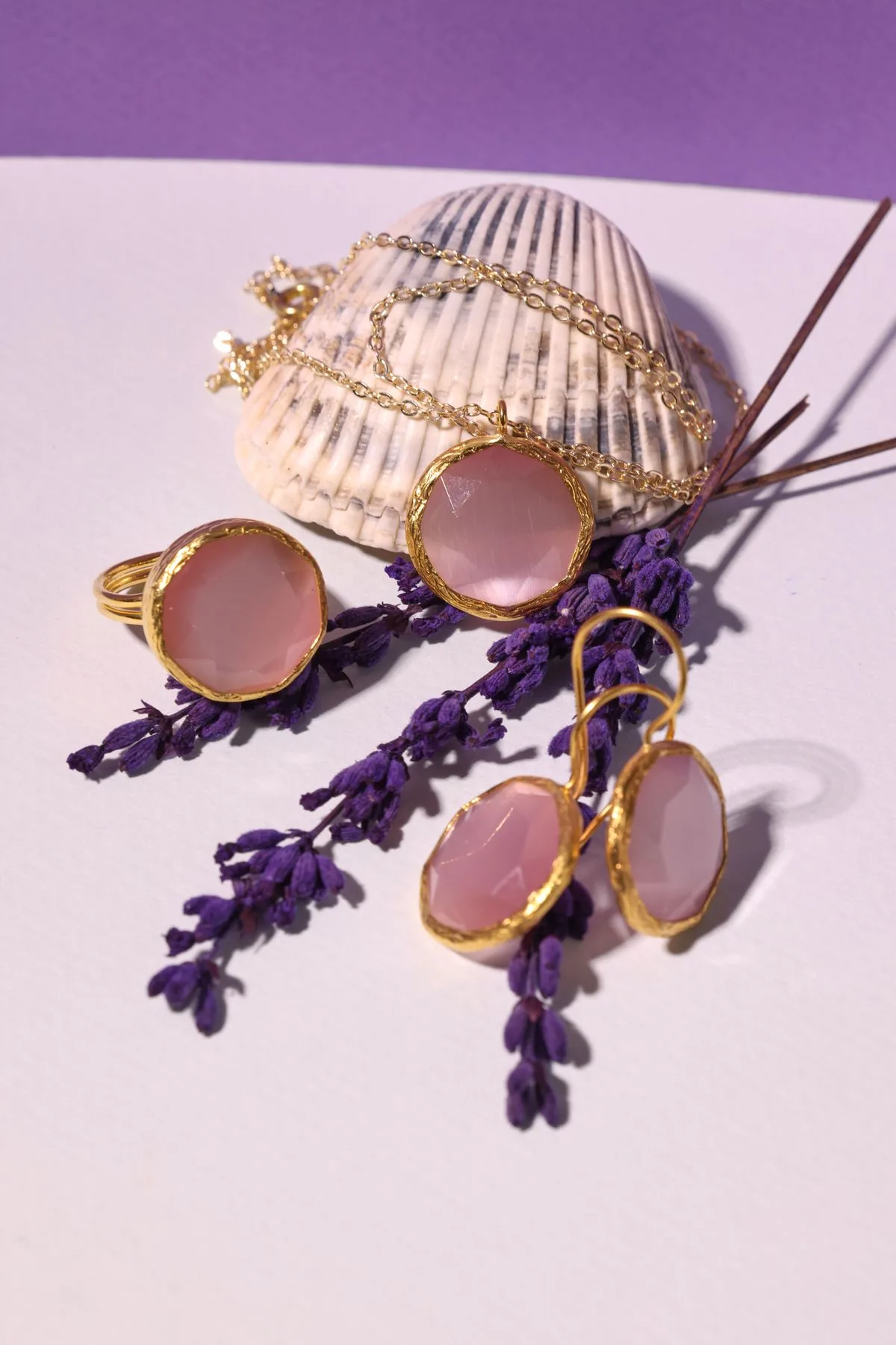 Gold-plated rose quartz ring styled with matching pendant and drop earrings